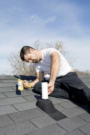 Roofing contractor fixing shingles during roof repairs