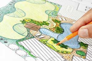 Person sketching landscaping ideas for Northern Virginia home