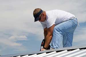 Roofing contractor installing new metal roof during a roof repair service