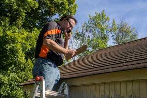 Roof repair contractor looking for warning signs of a damaged roof