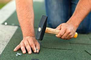 A Beyond Exteriors roof repair contractor installing newly replaced shingles