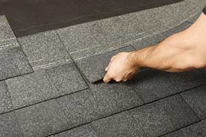 Roofing contractor laying shingles during Aldie, VA roof repair services