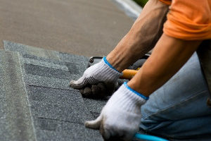 roof repair contractor laying down new shingles