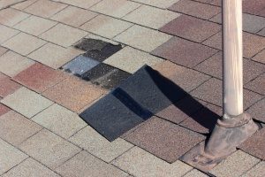 broken shingles indicating the need for at least a partial Fairfax, VA roof replacement