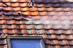 a metal roof undergoing a power wash as part of a roof maintenance package provided by a reputable roof repair contractor in Fairfax, VA