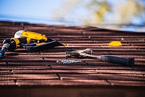 power tools on the top of a roof with roof buckling that needs a repair in order to be fixed