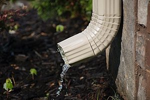 the downspout of a rain gutter system that is flowing properly and efficiently and thus not creating any need for a roof repair but it could still benefit from maintenance
