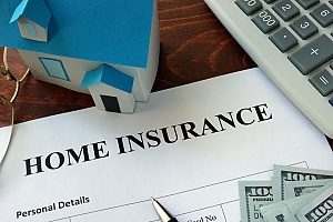 a homeowners insurance claim form, with a calculator, $100 bills and a small model home
