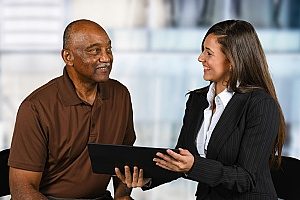 an insurance agent working with a homeowner to determine which forms of roof damage they can cover and what the homeowner will have to pay out of pocket