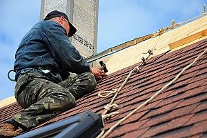 northern Virginia roof repair contractors that are fixing shingles on a roof that experienced roof damage over time from storms