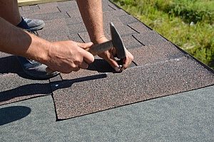 a roofing contractor installing shingles for a roof that has a manufacturer warranty in case the roof were to become defected