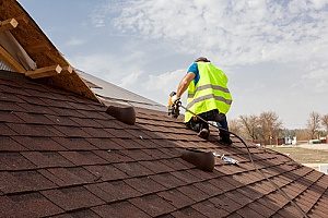 a roof replacement contractor working on a roof in Fairfax, VA that is covered by homeowners insurance