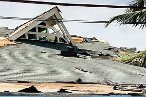 a damaged roof of a house where the homeowners have asked many insurance roof replacement questions