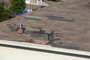 an old and damaged roof with brown shingles