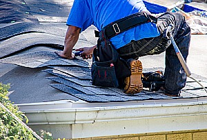 contractor repairing a damaged roof