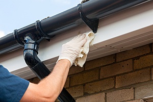 a homeowner cleaning roof flashing using roof repair products