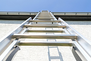 an extension ladder being used to repair a roof