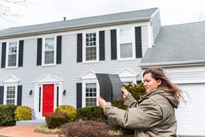 woman assessing what wind damage look like to her roof