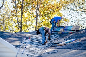 two men fixing a roof that learned how budgeting roofing repair costs helps