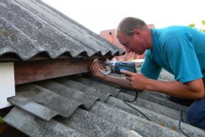 man replacing a gutter himself to reduce costs