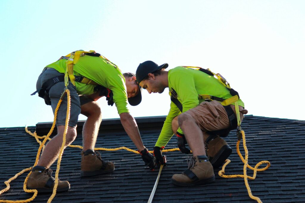 Two roofers inspecting a roof.